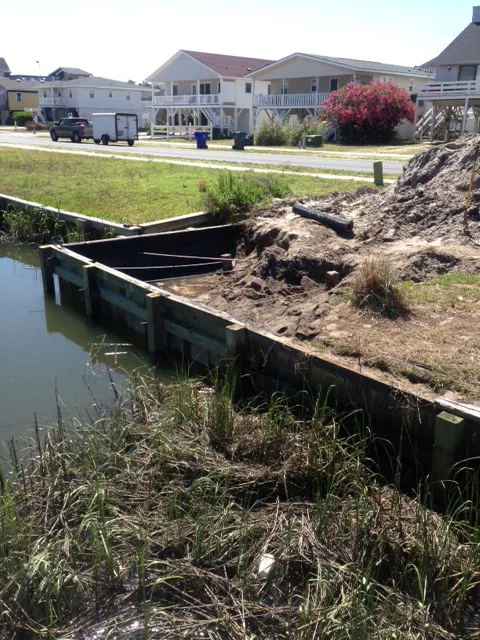 A wood bulkhead replacement in progress along a coastal canal