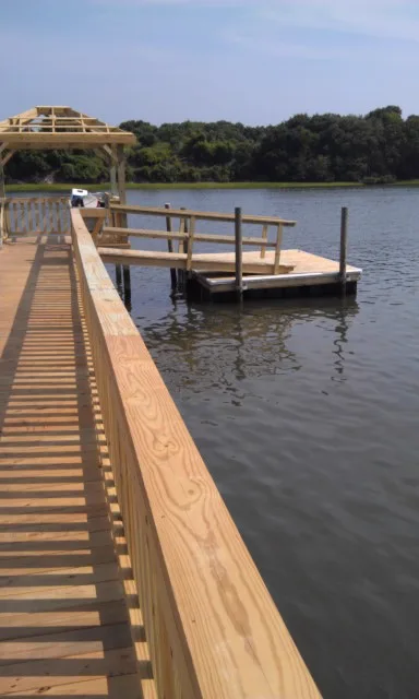 A fixed dock connected to a floating dock section on calm coastal water
