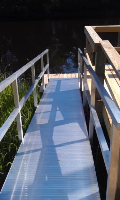 An aluminum gangway ramp leading down to a low-profile dock
